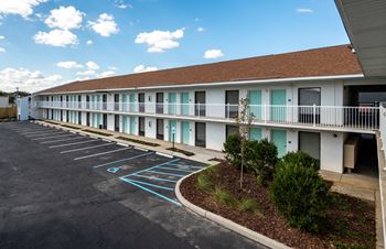 A parking lot in front of a building with blue painted spaces.